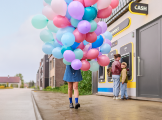 Persoon met veel ballonnen aan een nieuw CASH-punt.